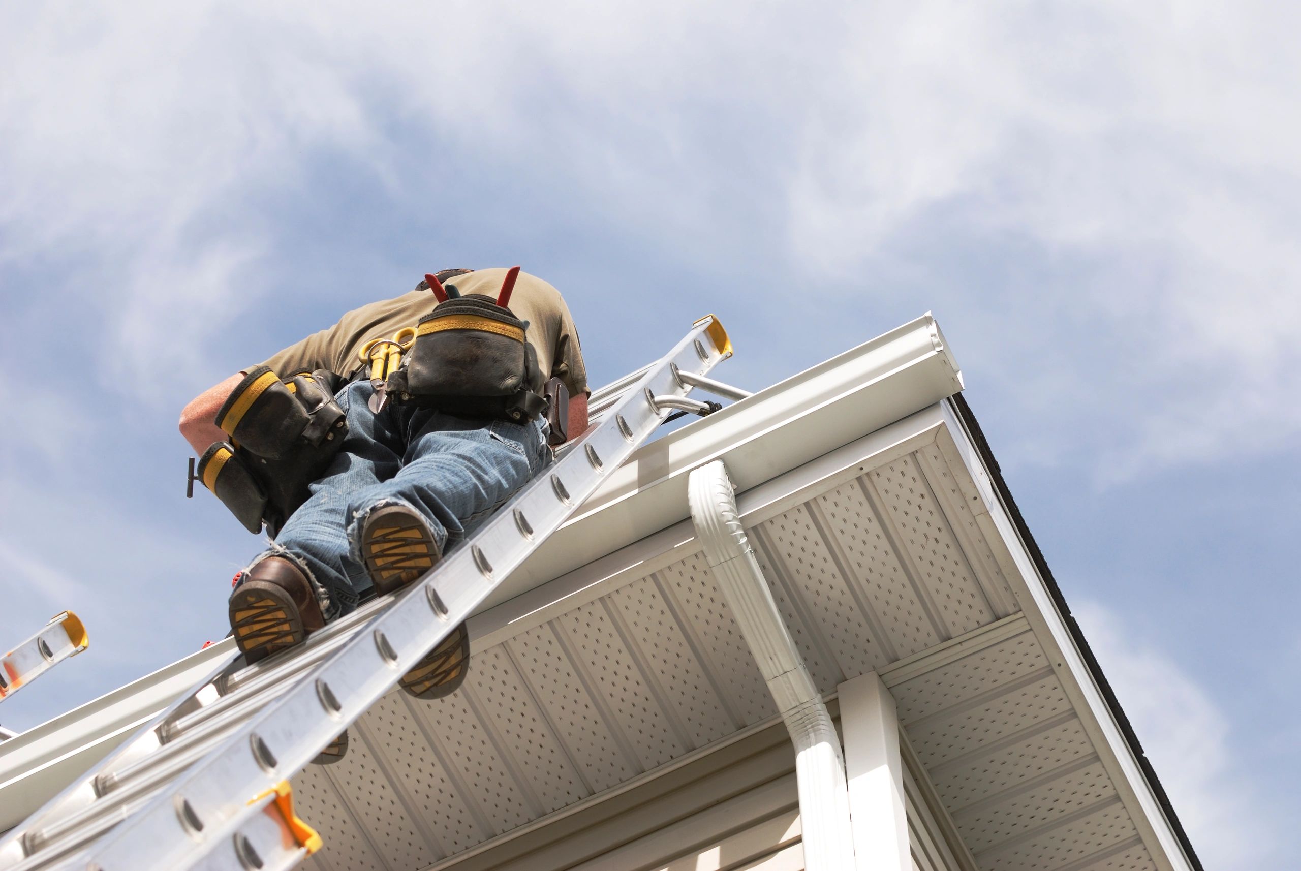 Technician cleaning leaves and debris from a gutter